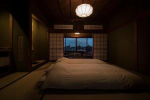 a bedroom with a large bed and a window at Yamanoo in Kanazawa