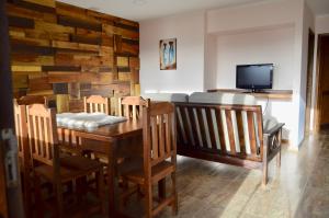 a dining room with a table and chairs and a tv at Patagonia Austral Suites in El Calafate