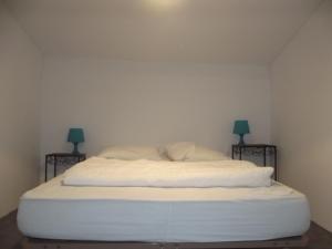 - un lit blanc dans une chambre avec deux lampes dans l'établissement 67 Rue des Manilles, au Grau-du-Roi