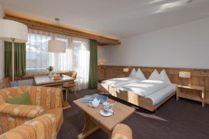 una camera d'albergo con un letto grande e un divano di Hotel Seraina a Sils Maria