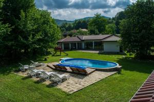 a backyard with a pool and chairs and a house at Gabarite Holiday Village in Apriltsi
