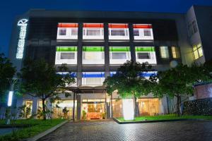 a building with green and red lights on it at Zhi Da Craft Service Guest House in Caotun