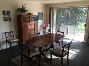 een eetkamer met een tafel en stoelen en een raam bij Yarram Cottage: Art and Accommodation in Yarram