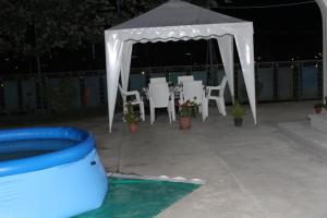 a gazebo with a table and chairs and a pool at Villa Near The Batumi in Batumi
