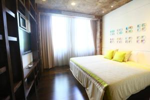 Un dormitorio con una cama con almohadas amarillas y una ventana en Zhi Da Craft Service Guest House en Caotun