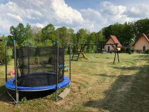 um parque infantil com um trampolim num campo em Ubytování Mája em Třeboň