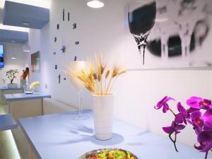 a table with a vase with flowers and a plate of food at Hotel Perla Gaia in San Vito lo Capo