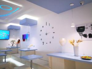 a room with blue tables and a clock on the wall at Hotel Perla Gaia in San Vito lo Capo