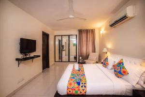 um quarto de hotel com uma cama e uma televisão em FabHotel Anutham Saket em Nova Deli