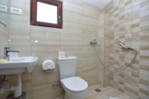 uma casa de banho com um WC, um lavatório e um chuveiro em Hotel Grbalj em Budva