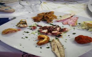 a white plate with different types of food on it at La Casa Dei Delfini in Lampedusa