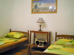 una camera con due letti e un tavolo con una lampada di Apartments Country House Stipica a Tuheljske Toplice