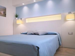 a bedroom with a blue bed with two pillows at Hotel Perla Gaia in San Vito lo Capo