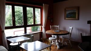 ein Zimmer mit Tisch und Stühlen und einem Fenster in der Unterkunft Posada Las Mañanitas in Cóbreces
