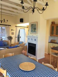 a living room with a table and a fireplace at Breede View Holiday Home in Witsand