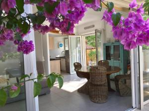a room with a table and some purple flowers at Villa L'Amiraute in Agde
