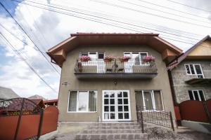 ein Haus mit einem Balkon mit Blumen darauf in der Unterkunft U Maksa in Solotschyn