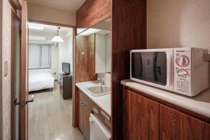 a kitchen with a microwave and a refrigerator at FLEXSTAY INN Iidabashi in Tokyo
