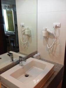 uma casa de banho com um lavatório e um espelho em Aloha Hatyai Hotel em Hat Yai