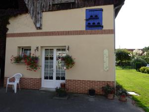 a house with a blue door and a white chair at La Fontainoise in Fontaine-sur-Somme