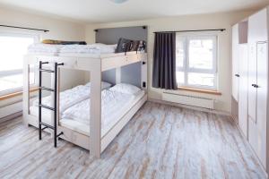 two bunk beds in a room with two windows at Oberstdorf Hostel in Oberstdorf