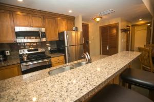 a kitchen with a granite counter top and stainless steel appliances at Sundial Lodge Condo Steps from Red Pine Gondola in Park City