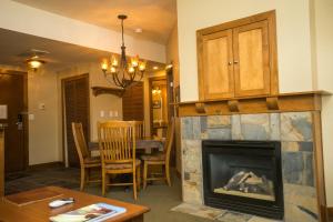 a living room with a fireplace and a table at Sundial Lodge Condo Steps from Red Pine Gondola in Park City