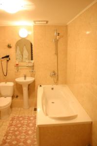 a bathroom with a tub and a toilet and a sink at Hotel Turist in Yuzhno-Sakhalinsk