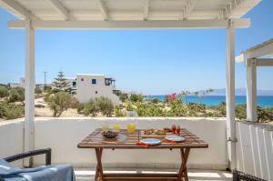 a table on a patio with a view of the ocean at Orkos Blue Coast in Mikri Vigla