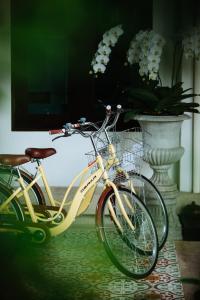 Deux vélos sont garés à côté d'un vase fleuri. dans l'établissement Na Nirand Romantic Boutique Resort, à Chiang Mai