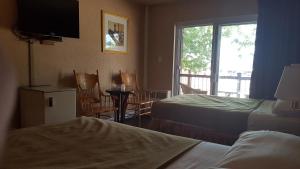 a hotel room with two beds and a balcony at Chomedey Inn in Laval