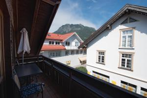 a balcony with a table and an umbrella at Ferienwohnung Fauser in Oberstdorf
