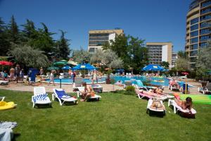 a group of people sitting in lawn chairs near a pool at Dunav Hotel in Sunny Beach