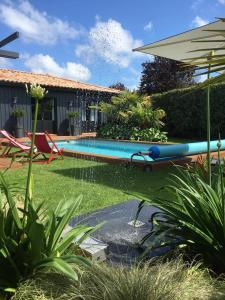 a pool with a water slide in a yard at Chambres d'hôte Ô Bois Plage in Gujan-Mestras