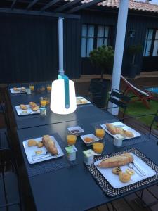 een tafel met borden eten en glazen sinaasappelsap bij Chambres d'hôte Ô Bois Plage in Gujan-Mestras