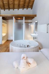 a bathroom with a tub with towels on a table at Somo Garden Villas in Somo