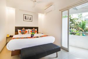 1 dormitorio con 1 cama grande con reposapiés negro en FabExpress Kalyan, en Vadodara