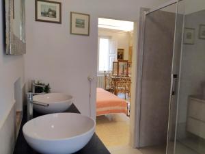 a bathroom with two sinks and a glass shower at Residenza storica Volta della Morte in Urbino +27 photos