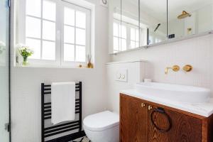 a bathroom with a sink and a toilet and a mirror at Veeve - Revitalising in Kensal Rise in London