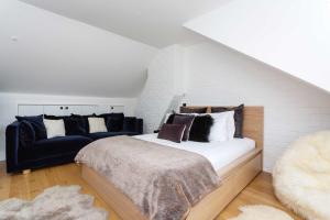 a bedroom with a large bed and a couch at Veeve - Revitalising in Kensal Rise in London