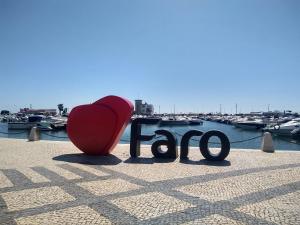 czerwone serce siedzące obok znaku z przystanią w obiekcie Melaya Budget Hostel w Faro