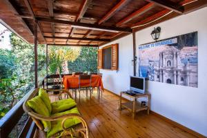 Zimmer mit einem Balkon mit einem Tisch und einem TV. in der Unterkunft Ecocasette in Syrakus