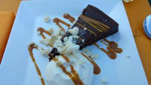 un morceau de gâteau au chocolat sur une assiette blanche dans l'établissement Logis Hôtel Restaurant Le Mas De L'Olivier, à Pont-Saint-Esprit