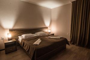 una camera da letto con un letto con due asciugamani sopra di Hotel Beni a Akhaltsikhe