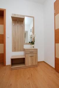 een badkamer met een spiegel en een houten kast bij Boutique Apartments in Hévíz