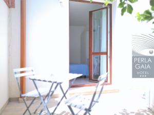 a room with two chairs and a table and a mirror at Hotel Perla Gaia in San Vito lo Capo