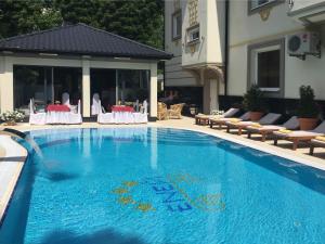 a large blue swimming pool with chairs and a building at Economy room in Hotel Eney in Lviv