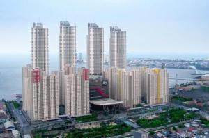 a group of tall buildings in a city at Apt Greenbay Baywalk Mall Pluit Seaside 2 Bedroom with Pool Facility in Jakarta