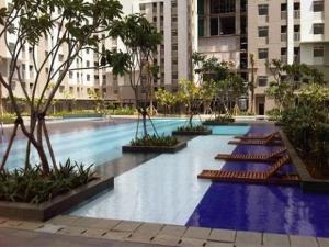 a large swimming pool in a city with tall buildings at Apt Greenbay Baywalk Mall Pluit Seaside 2 Bedroom with Pool Facility in Jakarta