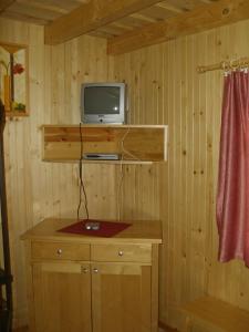 a room with a desk with a television on a wall at Chaty Dagmar in Liptovský Mikuláš